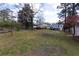 Large backyard featuring mature trees, grassy area, and a utility shed with potential for gardening at 1316 Milstead Ave, Conyers, GA 30012