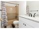 Bathroom with white vanity with granite countertop and tub with tile surround at 1316 Milstead Ave, Conyers, GA 30012