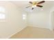 Empty carpeted bedroom with a ceiling fan and natural light from two windows at 1316 Milstead Ave, Conyers, GA 30012