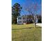 Well-manicured lawn with mature tree framing the front elevation of the two-story home at 1316 Milstead Ave, Conyers, GA 30012