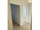 Hallway with neutral carpet, white trim, and open doorway to a sunlit room with windows at 1316 Milstead Ave, Conyers, GA 30012