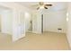 Living space featuring French doors, neutral carpet, a ceiling fan, and access to the staircase at 1316 Milstead Ave, Conyers, GA 30012