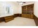 Cozy living room with custom built-in shelves and wood-paneled walls leading to the next room at 1316 Milstead Ave, Conyers, GA 30012