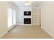 Living room with fireplace, built-in bookshelves, neutral carpet and French doors at 1316 Milstead Ave, Conyers, GA 30012