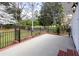 This patio area has black iron fencing, brick trim, exterior lighting and colorful flowers at 1316 Milstead Ave, Conyers, GA 30012