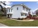 Rear view of the white home that features brick accents, a fenced yard and well-maintained landscaping at 1316 Milstead Ave, Conyers, GA 30012