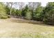 Large backyard features grass, trees, a wood fence, and a retaining wall at 4820 Marina Ln, Mableton, GA 30126