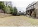 View of the backyard showing grass and trees with a portion of the brick house visible at 4820 Marina Ln, Mableton, GA 30126