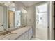 Bathroom featuring double sinks, granite countertop, white cabinetry and view into ensuite bedroom at 4820 Marina Ln, Mableton, GA 30126