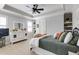 Bedroom featuring a patterned carpet, neutral wall paint, tray ceiling, ceiling fan and white dresser at 4820 Marina Ln, Mableton, GA 30126