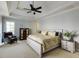 Bright bedroom with neutral walls, carpet, tray ceiling, ceiling fan and wooden furniture at 4820 Marina Ln, Mableton, GA 30126