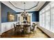 Formal dining room featuring rich blue walls, wainscoting, hardwood floors, and large windows at 4820 Marina Ln, Mableton, GA 30126