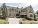 Stunning stone-clad home features a circular driveway, three-car garage, and lush landscaping at 4820 Marina Ln, Mableton, GA 30126