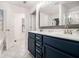 Bathroom featuring a double sink vanity with blue cabinets, a large mirror and a shower at 1530 Redbud Way, Tucker, GA 30083