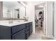 Bright bathroom featuring a double sink vanity with blue cabinets and a walk-in closet at 1530 Redbud Way, Tucker, GA 30083