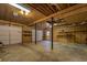 Large unfinished basement with wood paneling, concrete floors, storage shelves, and garage doors at 2070 Sweetgum Trl, Cumming, GA 30041