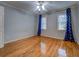 Bedroom with hardwood floors, ceiling fan and blue patterned curtains at 2070 Sweetgum Trl, Cumming, GA 30041