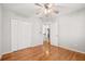 Bright bedroom with wood floors, ceiling fan, and white closet doors at 2070 Sweetgum Trl, Cumming, GA 30041