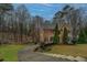 Expansive front yard featuring a paved driveway with steps to the traditional brick home and its manicured landscaping at 2070 Sweetgum Trl, Cumming, GA 30041