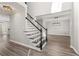 Inviting foyer with wood-look flooring, a staircase with dark wood accents, and a view into adjoining living spaces at 2070 Sweetgum Trl, Cumming, GA 30041