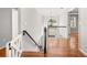 Hallway features hardwood flooring, staircase and white railing. A chandelier hangs in the hallway at 2070 Sweetgum Trl, Cumming, GA 30041