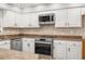 Close up shot of kitchen with white cabinets, stainless steel appliances, granite countertops, and tile backsplash at 2070 Sweetgum Trl, Cumming, GA 30041