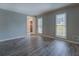 Bright living room featuring neutral walls, large windows, and luxury vinyl flooring at 2070 Sweetgum Trl, Cumming, GA 30041