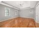 Spacious main bedroom featuring tray ceiling, hardwood floors, ceiling fan, and ample natural light at 2070 Sweetgum Trl, Cumming, GA 30041