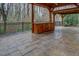 An outdoor kitchen under a pavilion with a wooden countertop provides a perfect spot for outdoor entertaining at 2070 Sweetgum Trl, Cumming, GA 30041