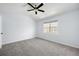 Bright bedroom featuring neutral carpet, a ceiling fan, and a large window allowing ample natural light at 217 Enterprise Path, Hiram, GA 30141