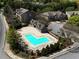Aerial view of community pool, garages, and townhomes with mature trees and manicured landscaping at 2296 Whiteoak Se Dr, Smyrna, GA 30080