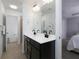Bright bathroom featuring a double vanity with dark cabinets, a large mirror, and tiled flooring at 2296 Whiteoak Se Dr, Smyrna, GA 30080