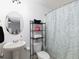 Bathroom with a pedestal sink, toilet with shelving, and shower featuring a palm leaf curtain at 2296 Whiteoak Se Dr, Smyrna, GA 30080