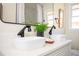 Bright bathroom featuring a double sink vanity with modern black fixtures and a decorative fern at 2722 Glenbriar Ne Dr, Atlanta, GA 30345