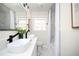 Bright bathroom featuring a double sink vanity with modern black fixtures and marble-look shower/tub at 2722 Glenbriar Ne Dr, Atlanta, GA 30345