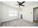 Bedroom with plush carpeting, two windows, ceiling fan, and an ensuite bathroom through the doorway at 2722 Glenbriar Ne Dr, Atlanta, GA 30345