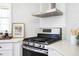 Modern kitchen with stainless steel range, hood, white cabinets, and subway tile backsplash at 2722 Glenbriar Ne Dr, Atlanta, GA 30345