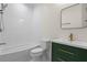 Contemporary bathroom with a tub, toilet, and a stylish green vanity with gold accents at 7630 Glisten Ave # 304, Atlanta, GA 30328