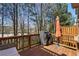 A wood deck includes a grill and patio umbrella overlooking a wooded landscape at 7630 Glisten Ave # 304, Atlanta, GA 30328