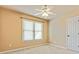 Neutral colored bedroom with window, ceiling fan, and standard door at 2046 Woodside Park Dr, Woodstock, GA 30188