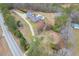 Brick home with a long driveway, pool, and expansive green space surrounded by trees, as seen from above at 2716 Georgia 16, Carrollton, GA 30116