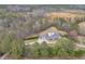 Aerial view of a brick home with a swimming pool, garages, and a long driveway surrounded by trees at 2716 Georgia 16, Carrollton, GA 30116