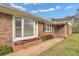 Charming brick home entrance with a bay window, flower bed, walkway, and manicured lawn at 2716 Georgia 16, Carrollton, GA 30116