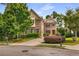 Two-story brick home featuring an attached garage, a well-manicured lawn, and mature trees at 2750 Vinings Orchard Se Cir, Atlanta, GA 30339