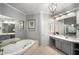 Elegant bathroom with a soaking tub, double vanities, large mirrors, and modern lighting at 2314 English Ivy Se Ct, Atlanta, GA 30339