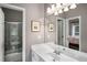 Well-lit bathroom featuring a sleek vanity, large mirror, and a shower/tub combo with glass doors at 2314 English Ivy Se Ct, Atlanta, GA 30339