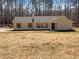 Charming single-story home with a neutral exterior and a well-maintained yard surrounded by a lush tree line at 70 Wall St, Hampton, GA 30228