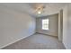 Neutral bedroom featuring a ceiling fan, neutral carpet, and a window allowing natural light at 955 Magnolia Gardens Walk, Mcdonough, GA 30253