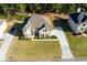 Aerial view of a brick home featuring a spacious driveway, lush lawn, and mature trees at 1368 Fall River Dr, Conyers, GA 30013