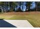 Spacious backyard with trees and grass and a concrete patio at 1368 Fall River Dr, Conyers, GA 30013